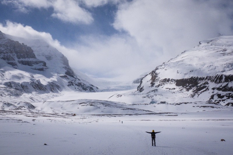 Person standing with arms open in Athabasca Glacier and Columbia Icefield, Jasper National Park