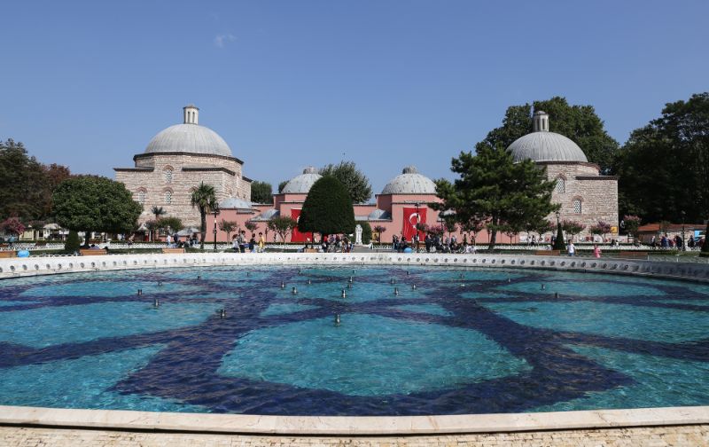 historical building with four domes with a blue pool in front. Sultan bath in Istanbul