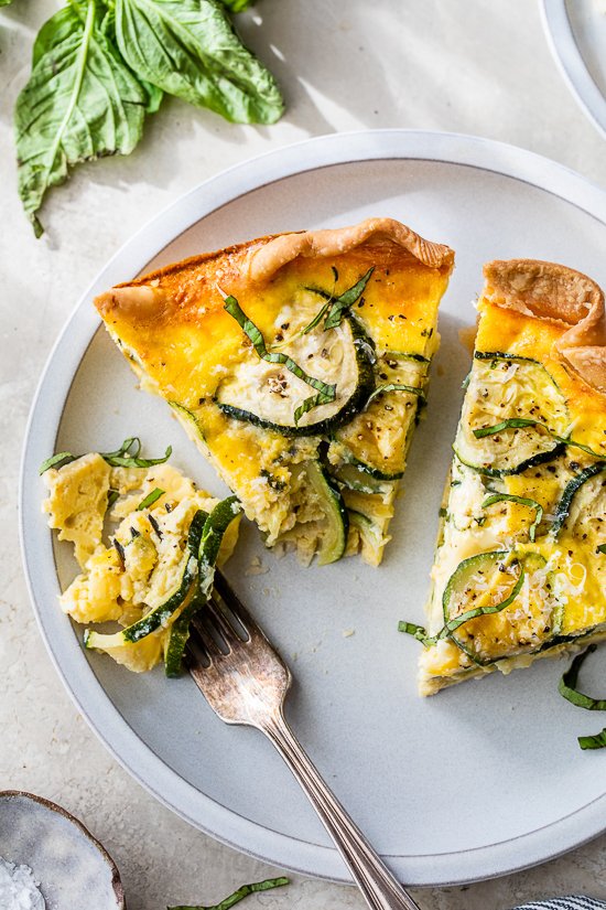 a wedge of quiche with basil and zucchini