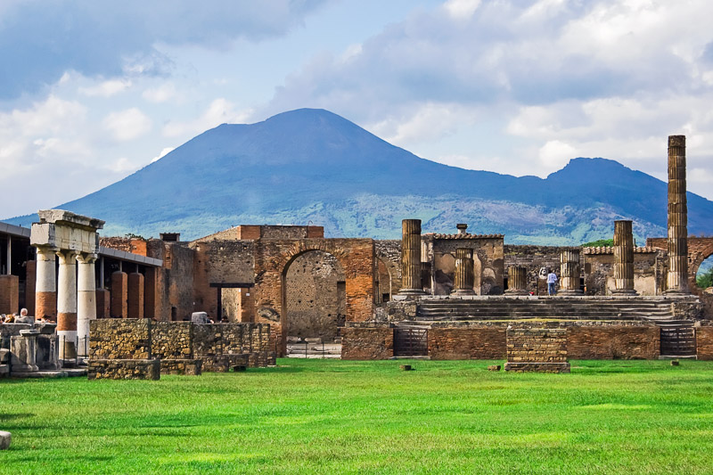 Ancient ruins of Pompeii with the volcano Vesuvius in the background