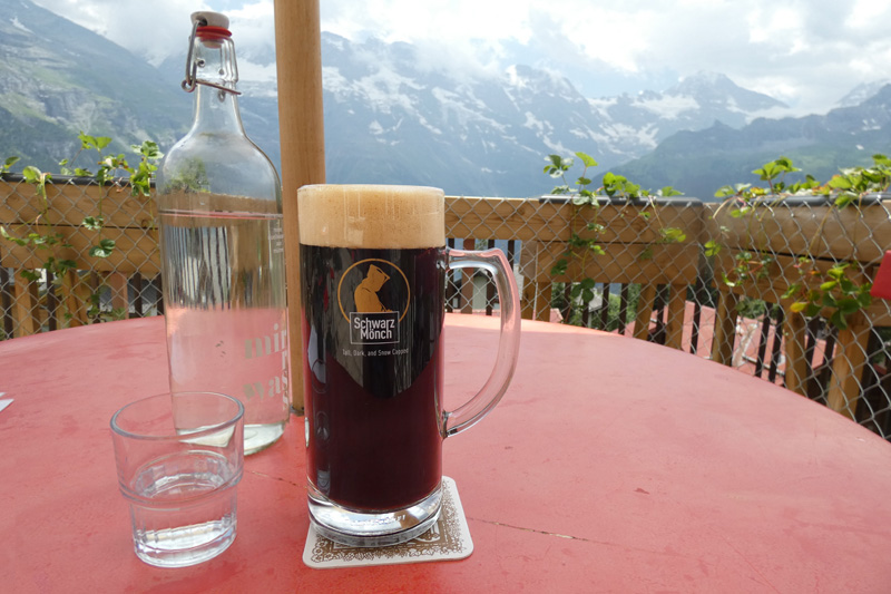 Black beer on table with view of mountains