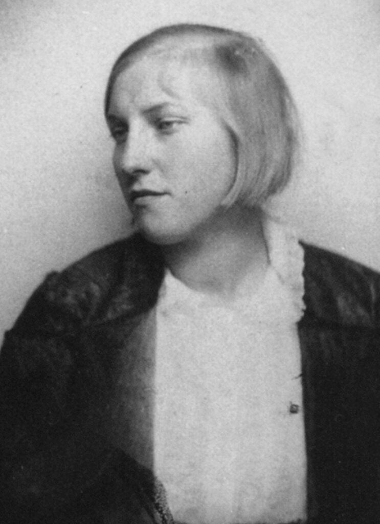 A black-and-white photo of a young blonde-haired woman looking off to the side.