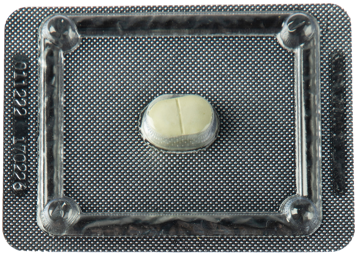 A close-up of a white mifepristone tablet still in its silver packaging.