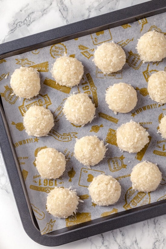 Unbaked macaroons with coconut on a baking sheet