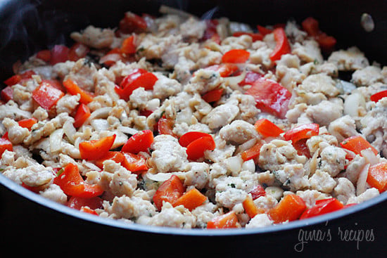 chicken sausage chunks and veggies satueed in a pan.