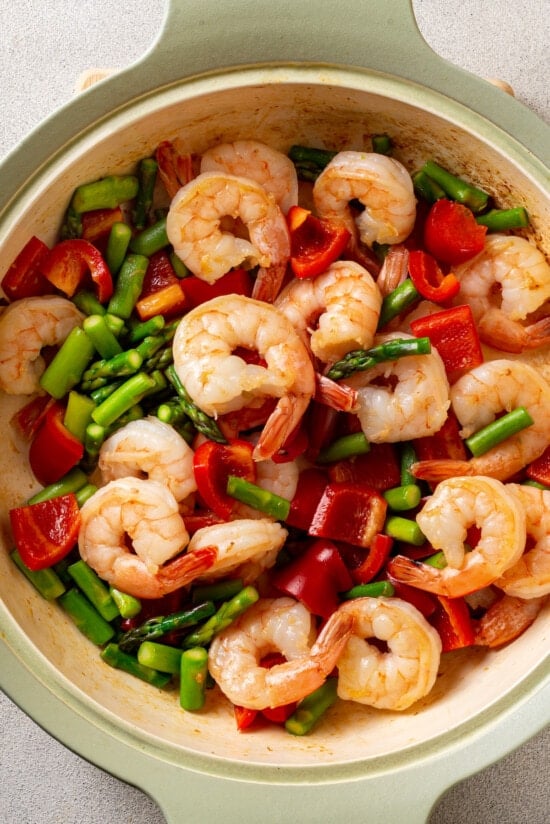 Shrimp, asparagus, and red bell peppers in a frying pan