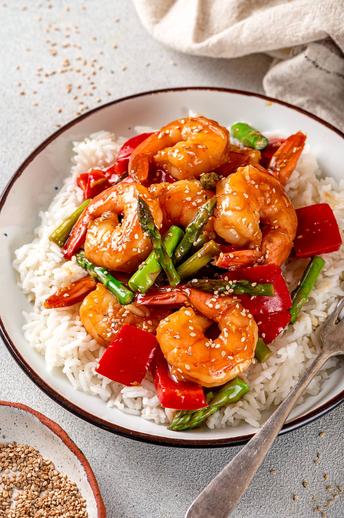 Shrimp and vegetables in a bowl over rice.