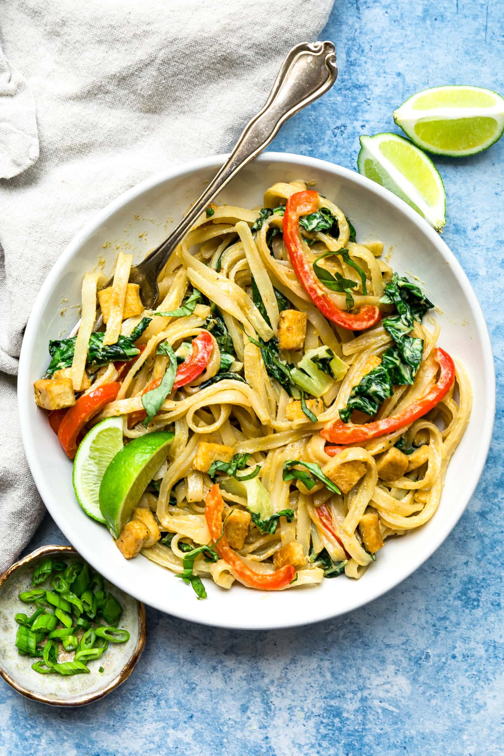 Green Curry Noodles in a bowl with limes.